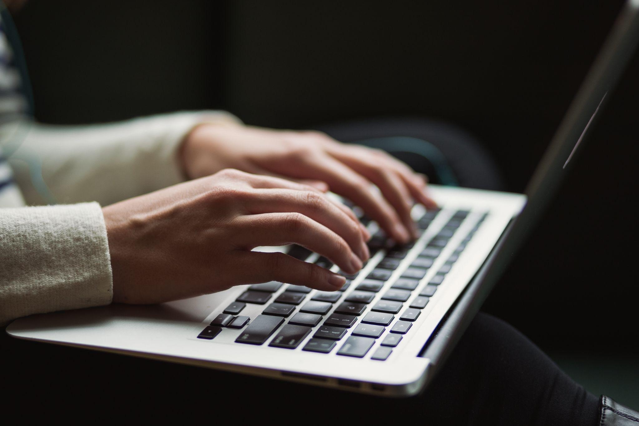 hand typing on a laptop